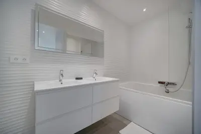 a white bathroom with a sink and a tub at REF 1425 - Cannes Center - Apartment for rent in Cannes