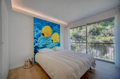 a bedroom with a bed and a large window at REF 1425 - Cannes Center - Apartment for rent in Cannes