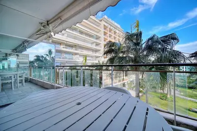 a table on a balcony with a view of a building at REF 1908 - Cannes Croisette - Apartment for rent in Cannes