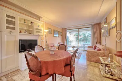 a dining room with a table and a living room at REF 1908 - Cannes Croisette - Apartment for rent in Cannes