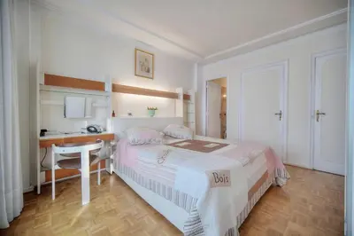 a white bedroom with a bed and a desk at REF 1908 - Cannes Croisette - Apartment for rent in Cannes