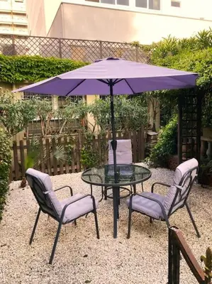 a table with two chairs and a purple umbrella at Centre-ville de Cannes 100 m mer in Cannes