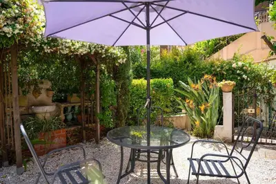 a table and chairs with a purple umbrella at Centre-ville de Cannes 100 m mer in Cannes