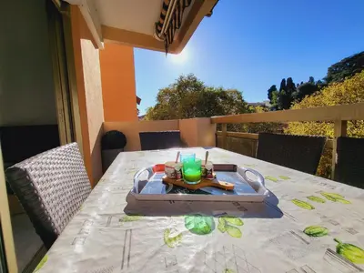 a tray of food on a table on a balcony at Charmant 2 pièces, traversant, clim, wifi, parking in Cannes