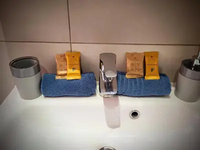 a bathroom sink with a knife and towels on it at Charmant 2 pièces, traversant, clim, wifi, parking in Cannes