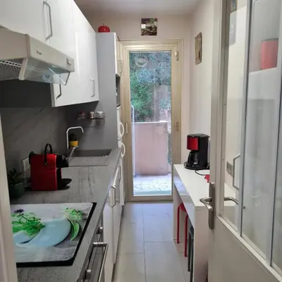 a small kitchen with a sink and a window at Charmant 2 pièces, traversant, clim, wifi, parking in Cannes