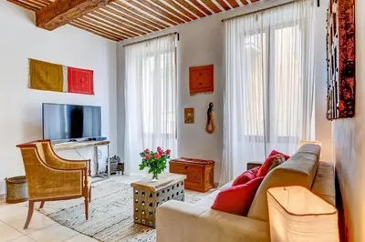 a living room with a couch and a tv at Cocoon'in Cannes Le Suquet in Cannes