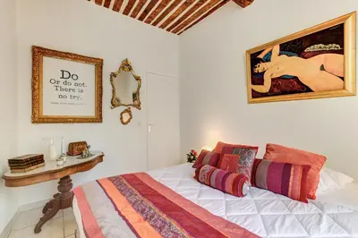 a bedroom with a bed and a painting on the wall at Cocoon'in Cannes Le Suquet in Cannes