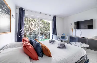a bedroom with a large window and a bed with pillows at Appartement disign CLUB B in Cannes
