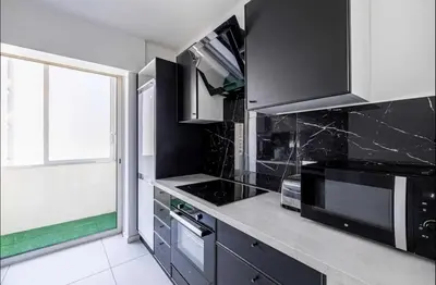 a kitchen with black and white appliances and a window at Appartement disign CLUB B in Cannes