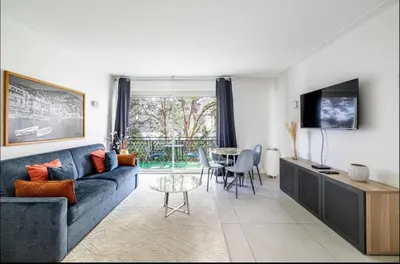 a living room with a blue couch and a table at Appartement disign CLUB B in Cannes