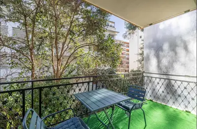 a patio with a table and chairs on a balcony at Appartement disign CLUB B in Cannes