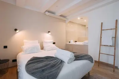 a bedroom with a large bed with white pillows at Bulle d'Amour - Jacuzzi, 10mn Palais&Plage, Centre in Cannes