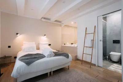 a bedroom with a large bed and a bathroom at Bulle d'Amour - Jacuzzi, 10mn Palais&Plage, Centre in Cannes