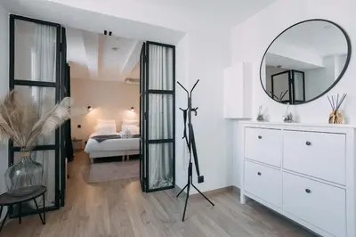 a white bedroom with a bed and a mirror at Bulle d'Amour - Jacuzzi, 10mn Palais&Plage, Centre in Cannes