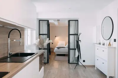 a kitchen with a sink and a mirror and a bedroom at Bulle d'Amour - Jacuzzi, 10mn Palais&Plage, Centre in Cannes
