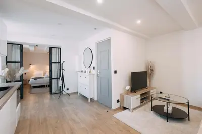 a white living room with a television and a bedroom at Bulle d'Amour - Jacuzzi, 10mn Palais&Plage, Centre in Cannes