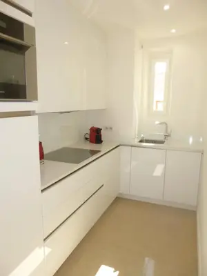 a white kitchen with white cabinets and a sink at REF 990 - Cannes Center - Apartment for rent in Cannes