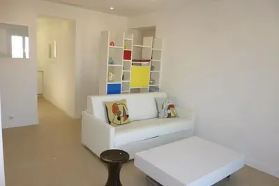 a living room with a white couch and a stool at REF 990 - Cannes Center - Apartment for rent in Cannes