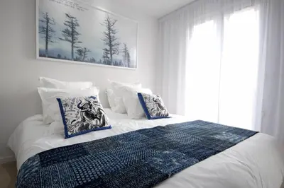 a bedroom with a bed with blue and white pillows at REF 945 - Cannes Center - Apartment for rent in Cannes