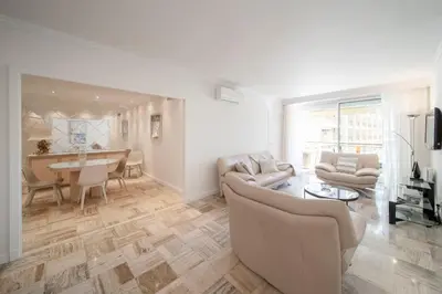 a living room with a couch and a table at REF 30 - Cannes Croisette - Sea and gardens view apartment for rent in Cannes
