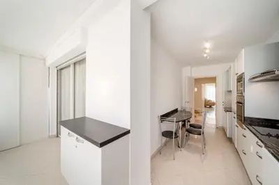 a kitchen with white cabinets and a black counter top at REF 30 - Cannes Croisette - Sea and gardens view apartment for rent in Cannes