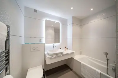 a white bathroom with a sink and a bath tub at REF 30 - Cannes Croisette - Sea and gardens view apartment for rent in Cannes