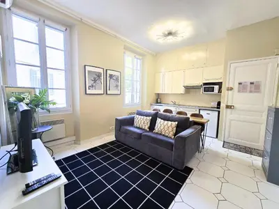 a living room with a couch and a kitchen at Forville Coeur de Cannes in Cannes