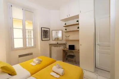 a bedroom with two yellow beds and a desk at Forville Coeur de Cannes in Cannes