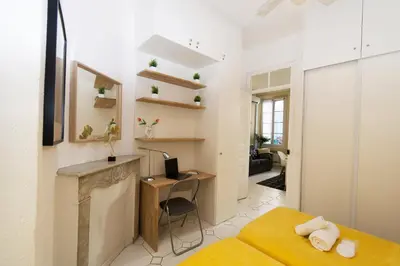 a bedroom with a desk and a bed in a room at Forville Coeur de Cannes in Cannes