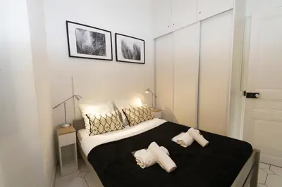 a bedroom with a large bed with two pillows at Forville Coeur de Cannes in Cannes