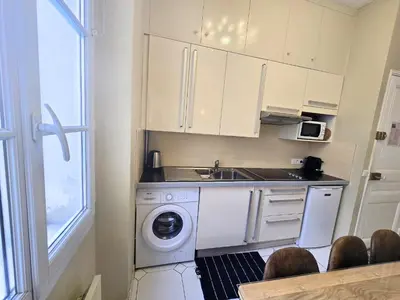 a kitchen with a washing machine and a sink at Forville Coeur de Cannes in Cannes