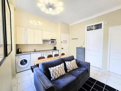 a living room with a couch and a kitchen at Forville Coeur de Cannes in Cannes