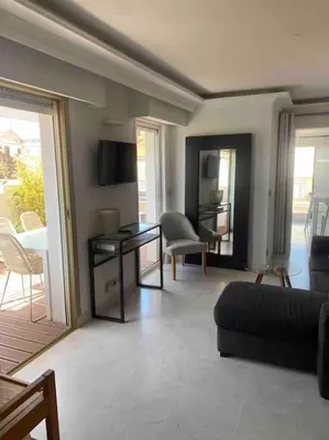 a living room with a couch and a table at Lumineux top terrasse 2P in Cannes