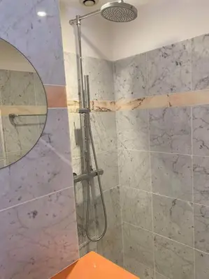 a bathroom with a shower with a mirror at Lumineux top terrasse 2P in Cannes