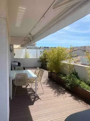 a patio with a white table and chairs on a balcony at Lumineux top terrasse 2P in Cannes
