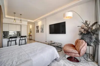 a bedroom with a bed and a tv and a chair at Luxury Superbe Studio MIRAMAR Croisette by RIVAEVENT in Cannes