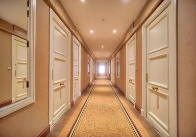 a long hallway with white doors and a mirror at Luxury Superbe Studio MIRAMAR Croisette by RIVAEVENT in Cannes