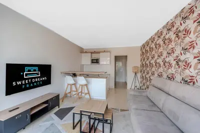 a living room with a couch and a kitchen at Le Grand Hôtel -Centre Croisette in Cannes