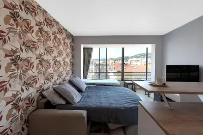 a bedroom with a bed and a desk and a window at Le Grand Hôtel -Centre Croisette in Cannes