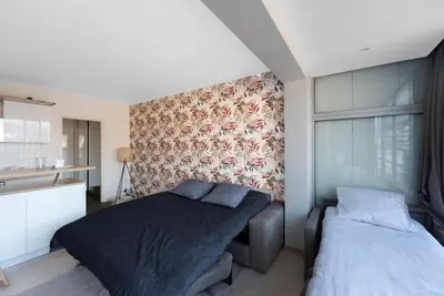 a bedroom with two beds and a kitchen at Le Grand Hôtel -Centre Croisette in Cannes