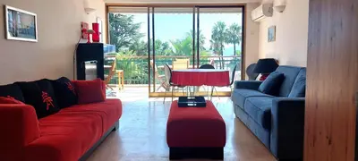 a living room with two couches and a table at Le Panoramique - Cannes - City Centre - Sea View - Swimming pool - Free Parking in Cannes