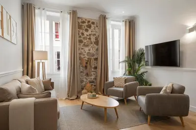 a living room with a couch and chairs and a tv at Cannes heart, 3 BR, 3 Bath, 100m Palais & beach in Cannes
