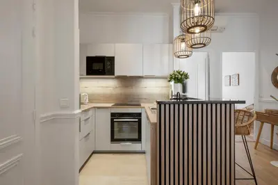 a kitchen with white cabinets and a black counter top at Cannes heart, 3 BR, 3 Bath, 100m Palais & beach in Cannes