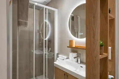 a bathroom with a shower and a sink and a mirror at Cannes heart, 3 BR, 3 Bath, 100m Palais & beach in Cannes