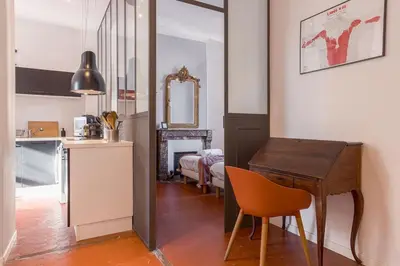 a kitchen with a table and a bedroom with a bed at L'Atelier - Jardin, 8mn Palais&Plage, spacieux in Cannes