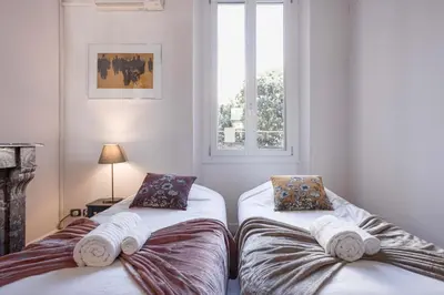 two twin beds in a room with a window at L'Atelier - Jardin, 8mn Palais&Plage, spacieux in Cannes