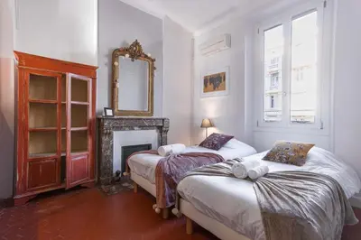 two beds in a room with a fireplace and a mirror at L'Atelier - Jardin, 8mn Palais&Plage, spacieux in Cannes