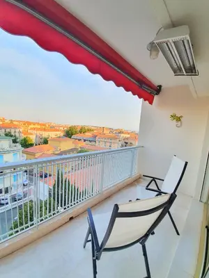 a balcony with a chair and a large window at Petit Juas by Welcome to Cannes in Cannes