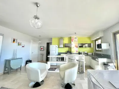 a kitchen with white furniture and yellow walls at Petit Juas by Welcome to Cannes in Cannes
